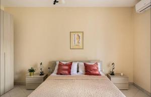 a bedroom with a large bed with red pillows at Aurora Apartment in Żurrieq
