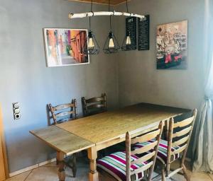 - une table et des chaises en bois dans la salle à manger dans l'établissement Urlaub im Grünen - Ferienwohnung EG im Brunnenhof, à Reichshof 
