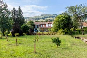 a row of trees in a field in front of a house at La Torrentera de Cantabria in Rada