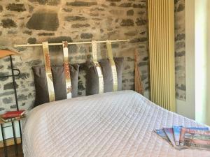 un letto in una camera da letto con parete in pietra di Casa Belvedere a Moltrasio