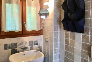 bagno con lavandino e specchio di Casa Belvedere a Moltrasio