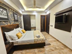 sypialnia z łóżkiem i wentylatorem sufitowym w obiekcie Hotel Linda Suites Near International Airport By LA CASA w Nowym Delhi