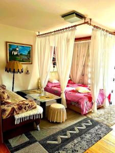 a bedroom with two beds with curtains and a rug at Apartmani GS ***** Zavidovici in Zavidovići