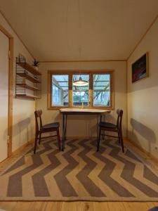 een kamer met een tafel, 2 stoelen en een raam bij The Walnut Cottage in Neustadt in Holstein