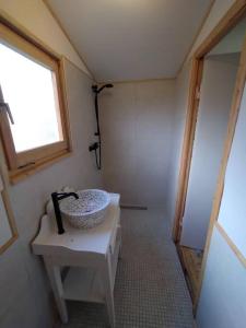 baño con lavabo blanco y ventana en The Walnut Cottage, en Neustadt in Holstein