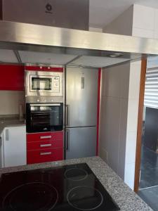 a kitchen with a stove and a microwave at Punta Salera house & beach in Pobra do Caramiñal