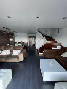 a large living room with couches and a staircase at Punta Salera house & beach in Pobra do Caramiñal