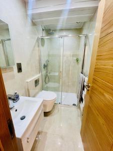 ein Bad mit einer Dusche, einem Waschbecken und einem WC in der Unterkunft 2 Bedroom Flat or Appartment near Heathrow with Garden in Uxbridge
