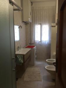a bathroom with a sink and a toilet at Dimora Cadò Alloggio Turistico Privato in Taranto