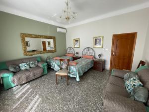 a living room with couches and a mirror at Dimora Cadò Alloggio Turistico Privato in Taranto