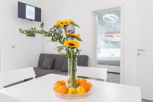 アヴォラにあるAlmond Houseのテーブルの上に花とオレンジが入った花瓶