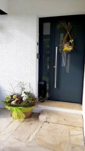a blue door of a house with a basket of flowers at L'Orée des Champs 