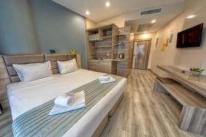 1 dormitorio con 1 cama grande y toallas. en My House N5 Suites Hotel, en Esenyurt