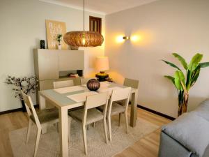 a dining room table and chairs in a living room at Praia de Vila do Conde com vista a mar in Vila do Conde