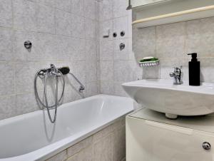 een badkamer met een wit bad en een wastafel bij Abrazo Sarajevo in Sarajevo +17 foto's