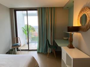 Schlafzimmer mit einem Bett, einem Schreibtisch und einem Fenster in der Unterkunft Villa: Piscine, proche Centre & Mer in Saint-Jean-de-Luz