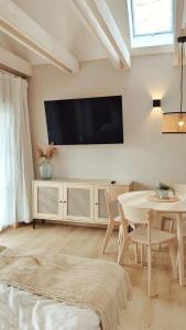 Mabé في Lauta: غرفة معيشة مع طاولة وتلفزيون على الحائط