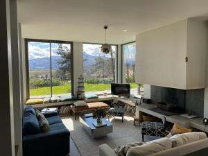 a living room with couches and a large window with a view at Villa: Piscine, proche Centre & Mer in Saint-Jean-de-Luz