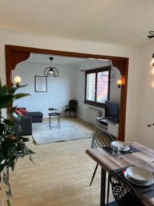 ein Wohnzimmer mit einem Tisch und einem Sofa in der Unterkunft La Terasse des Vignes - Maison 2 Chambres - 4 Personnes in Blienschwiller