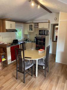 a kitchen with a table and chairs in a room at MOBIL HOME in Noyelles-sur-Mer