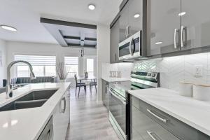 a kitchen with white counter tops and a sink at Sunny Perch Stay in Edmonton