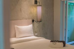 um quarto com uma cama com uma almofada branca e um candeeiro em Seaview Apartments - Karon Beach em Ka Rorn