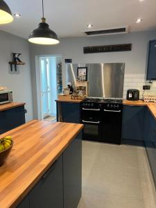 een keuken met blauwe kasten en een zwarte kachel bij Wentworth guesthouse in Whitby