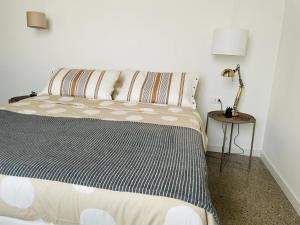 een slaapkamer met een bed en een lamp op een tafel bij La casa di Amos in Vaprio dʼAdda