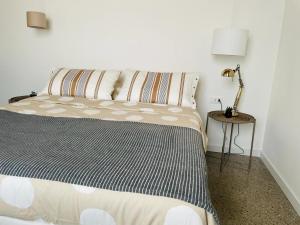 a bedroom with a bed and a lamp on a table at La casa di Amos in Vaprio dʼAdda +25 photos