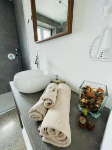 y baño con lavabo y toallas en la encimera. en La casa di Amos en Vaprio dʼAdda