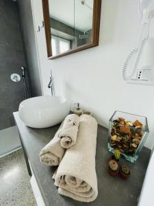 a bathroom with a sink and towels on a counter at La casa di Amos in Vaprio dʼAdda