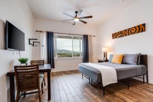 a bedroom with a bed and a desk and a window at Unit 2 Maui Ohana Modern Studio in Wailuku