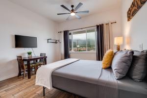 a bedroom with a bed and a desk and a window at Unit 2 Maui Ohana Modern Studio in Wailuku