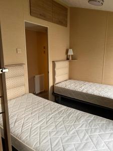 Habitación con 2 camas y puerta a un pasillo en Boston Lodge Sunnydale Jubilee way 5, en Saltfleet