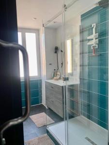 uma casa de banho com uma cabina de duche em vidro e um lavatório. em Maison de ville très lumineuse au centre ville em Dax