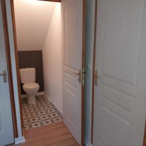 een open deur naar een badkamer met een toilet bij gîte le petit roussel in Putanges