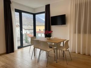 a dining room with a table and chairs and a large window at Bernina Suite in Tirano