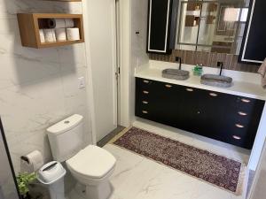 a bathroom with a toilet and a sink and a mirror at Refúgio nascer das águas in Gravatal +36 photos