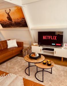 una sala de estar con un televisor y una mesa en The Forest Cabin Durbuy, en Durbuy 51 fotos más