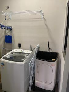 a laundry room with a washing machine and a sink at Refúgio nascer das águas in Gravatal