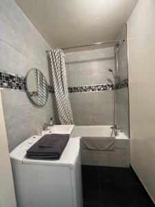 a bathroom with a tub and a sink and a shower at Cocon Parisien 12 min Paris - parking privé gratuit - Balcon - Wifi in Enghien-les-Bains