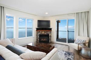 a living room with a fireplace and a tv at Kingfisher Pacific Resort & Spa in Courtenay