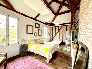 a bedroom with a bed and a brick wall at Authentique villa du XIX e siècle avec piscine in Lue