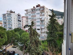 a large apartment building with trees in front of it at tuna doğa evi in Balcova