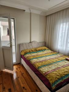 uma cama com uma colcha num quarto em tuna doğa evi em Balçova
