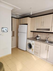 a kitchen with a white refrigerator and a dishwasher at tuna doğa evi in Balcova
