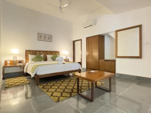 a large bedroom with a bed and a table at Saraca Resort & Spa Corbett in Garjia