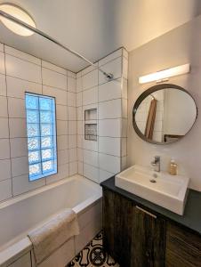 uma casa de banho com uma banheira, um lavatório e um espelho. em Gurus Of Gravel Bike Retreat Guest Suite em Clearwater