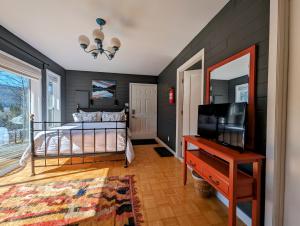 1 dormitorio con 1 cama, TV y mesa en Gurus Of Gravel Bike Retreat Guest Suite en Clearwater