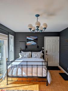 Un dormitorio con una cama con paredes azules y una lámpara de araña. en Gurus Of Gravel Bike Retreat Guest Suite en Clearwater